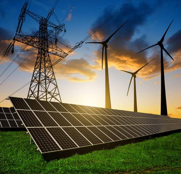 Transmission towers, wind turbines and solar panels at sunset